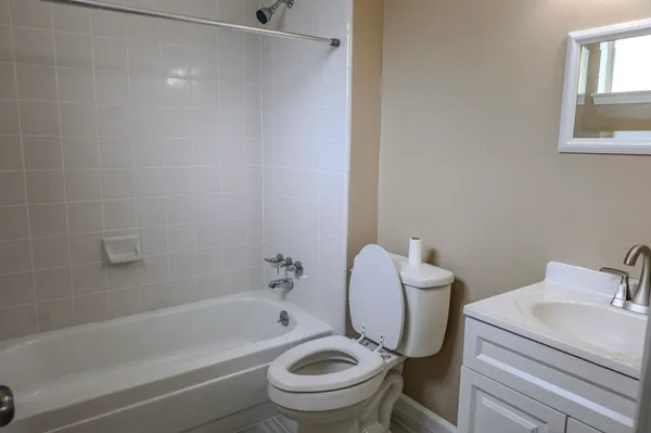 a white toilet sitting next to a bath tub