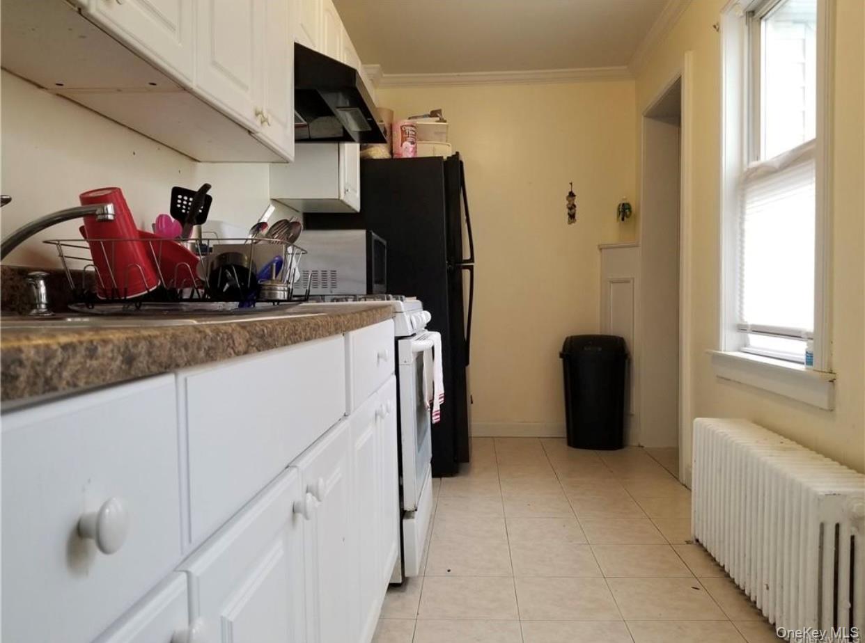 7 Clinton Street Haverstraw, NY 10927 - Photo 15 of 20 Kitchen featuring white cabinetry with matching hardware, a textured countertop, and tile flooring