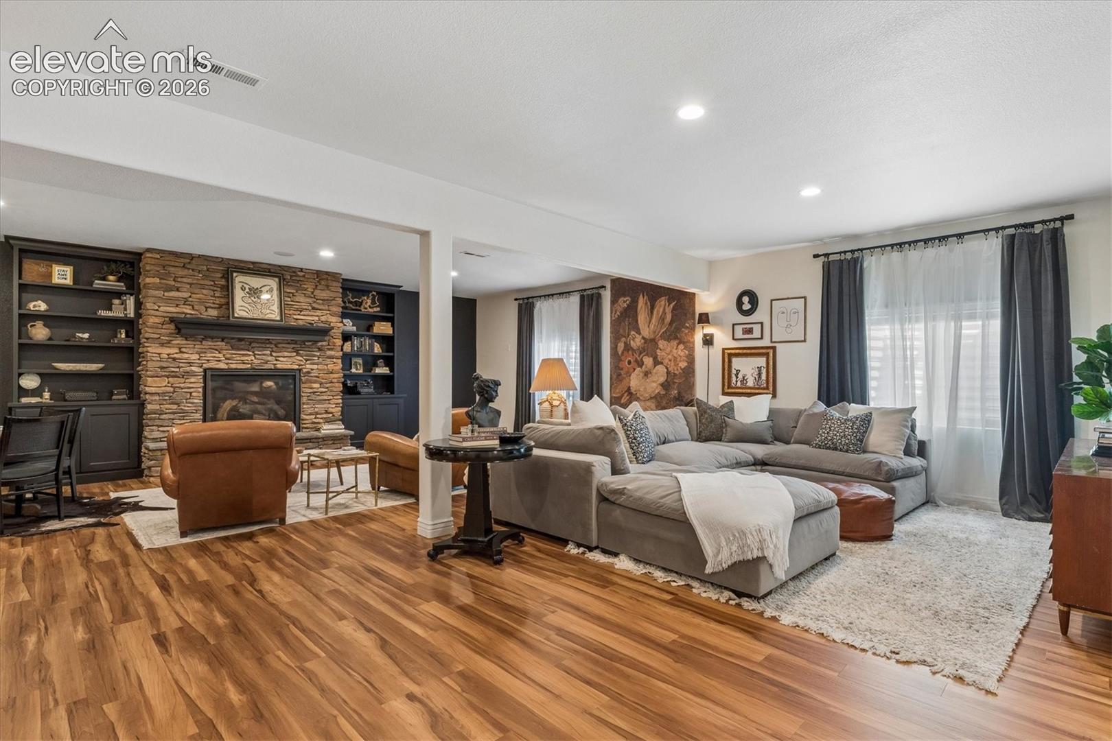 2388 Rusty Ridge Court Colorado Springs, CO 80921 - Photo 27 of 48 Spacious living area featuring wood-finish flooring, recessed lighting, and a stone-clad fireplace