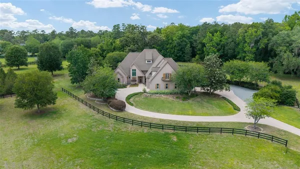 an aerial view of a house with a yard and lake view