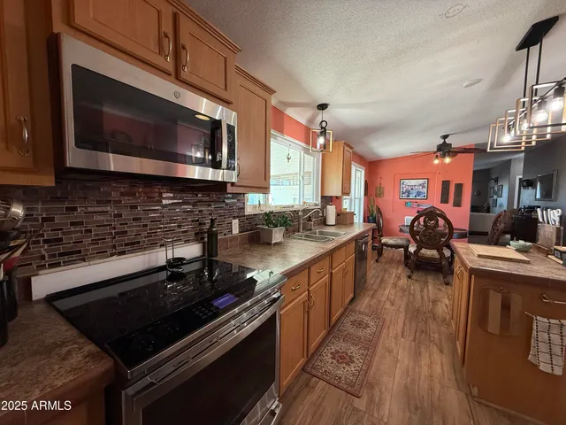 a living room with furniture a large window and wooden floor