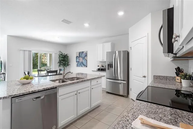 a large bed sitting in a bedroom next to a window with a dresser