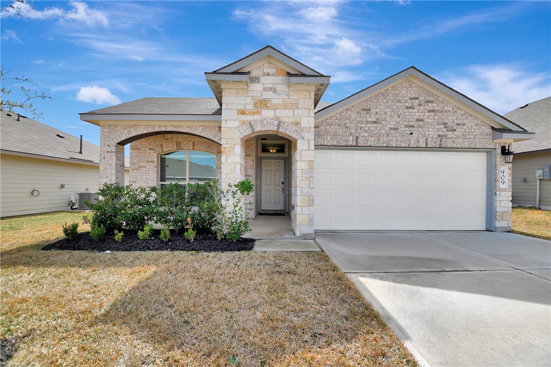 909 Davy Street Brenham, TX 77833 - Photo 4 of 35 Home with a garage, driveway, a front yard, and brick siding