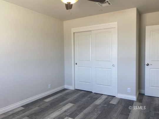1521 Mayo Street Ridgecrest, CA 93555 - Photo 17 of 24 an empty room with wooden floor closet and windows