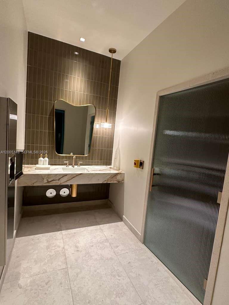 77 Southeast 5th Street, Unit 1815 Miami, FL 33131 - Photo 21 of 49 a bathroom with double vanity and a mirror