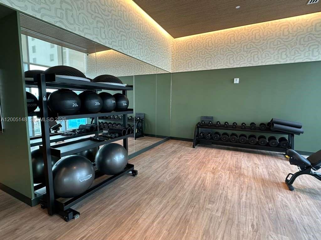 77 Southeast 5th Street, Unit 1815 Miami, FL 33131 - Photo 41 of 49 a room with gym equipment and wooden floor