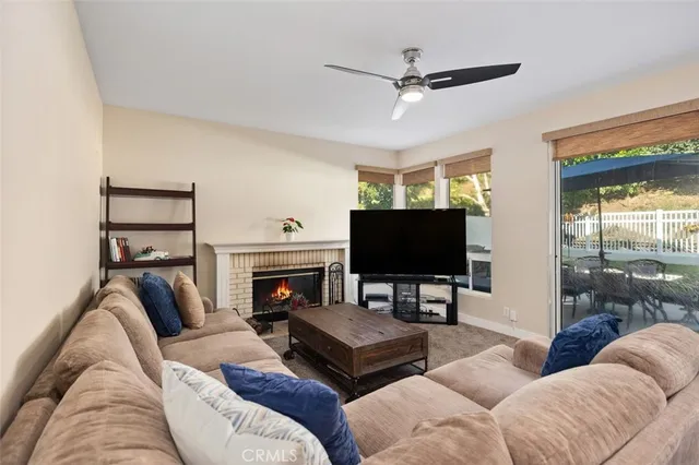 a living room with furniture a flat screen tv and a fireplace
