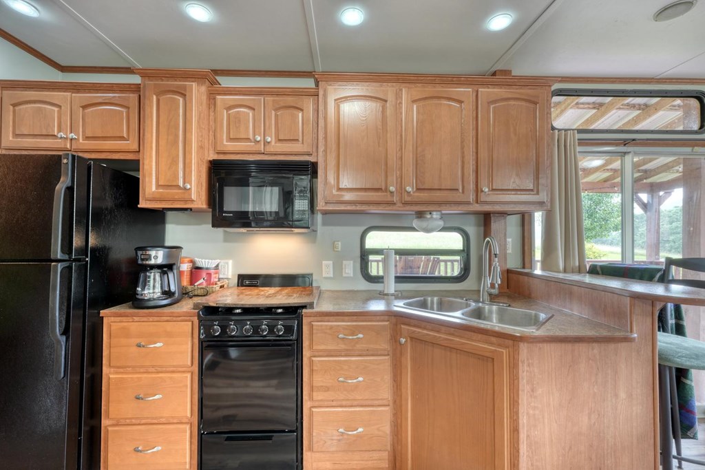 568 Parks Road Hiawassee, GA 30546 - Photo 15 of 38 a kitchen with stainless steel appliances granite countertop a stove a sink and a microwave