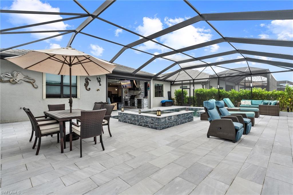 19656 The Pl Boulevard Estero, FL 33928 - Photo 7 of 42 a view of a patio with table and chairs under an umbrella