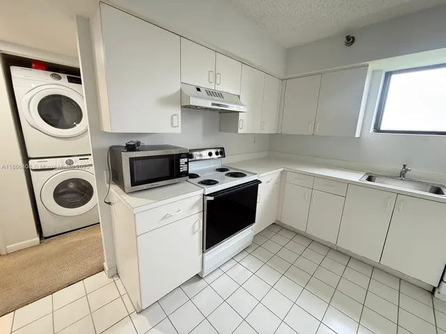 a kitchen with a stove top oven and a sink