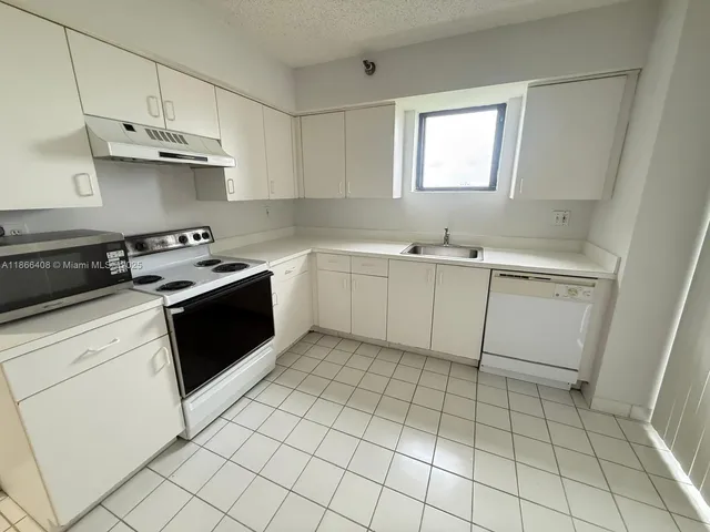 a kitchen with a stove sink and cabinets