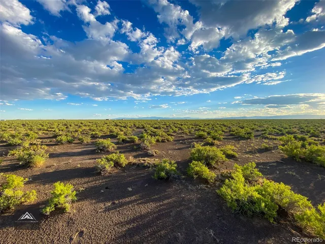 a view of a city with lots of residential buildings ocean and mountain in the back