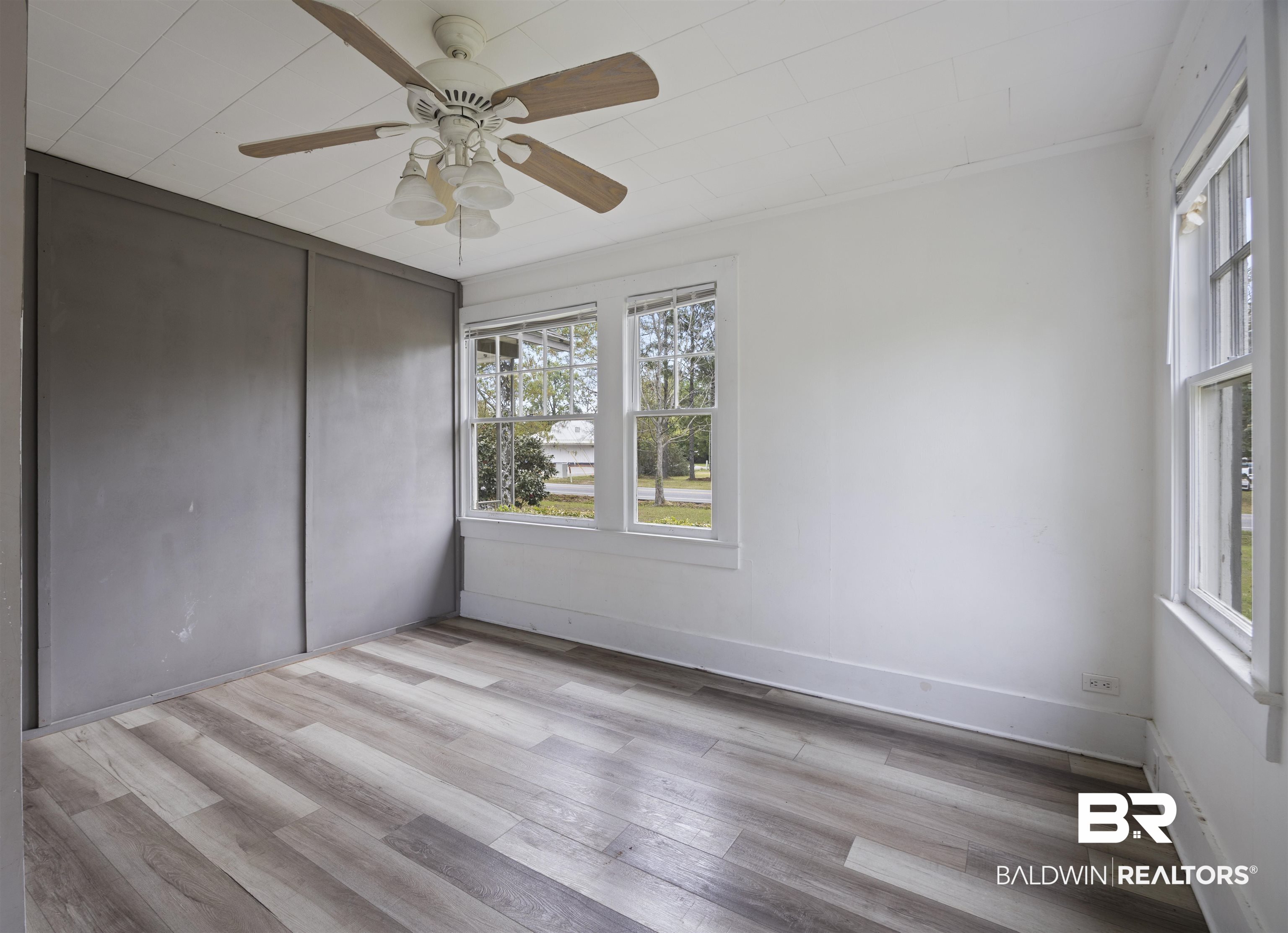 112 South Juniper Street Foley, AL 36535 - Photo 34 of 64 Unfurnished bedroom featuring light wood-style flooring, a ceiling fan, and a closet