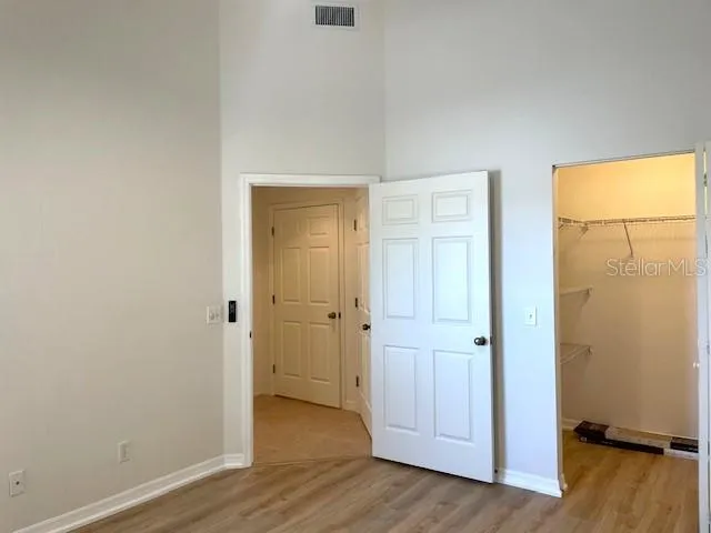 an empty room with wooden floor and a bathroom