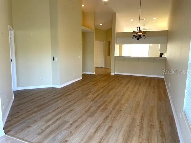 wooden floor in an empty room with a kitchen