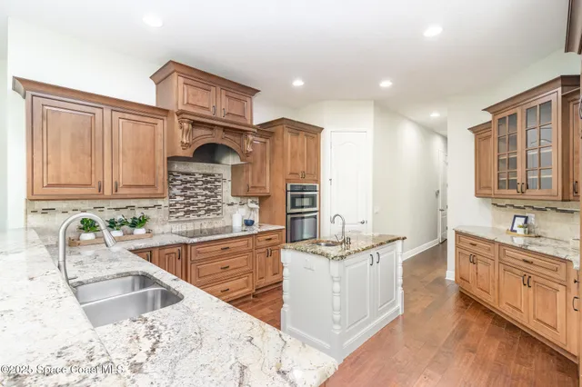a kitchen with stainless steel appliances granite countertop a sink stove and cabinets