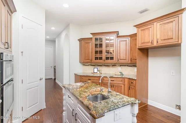a kitchen with granite countertop a sink stove and cabinets
