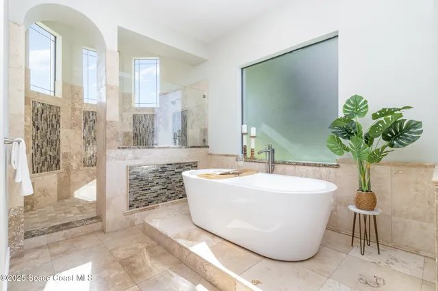 a white bath tub sitting in a bathroom next to a white tub