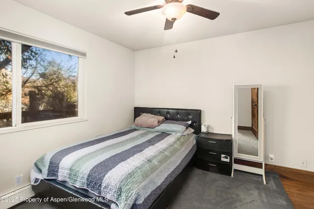 a bedroom with a bed and a painting on the wall