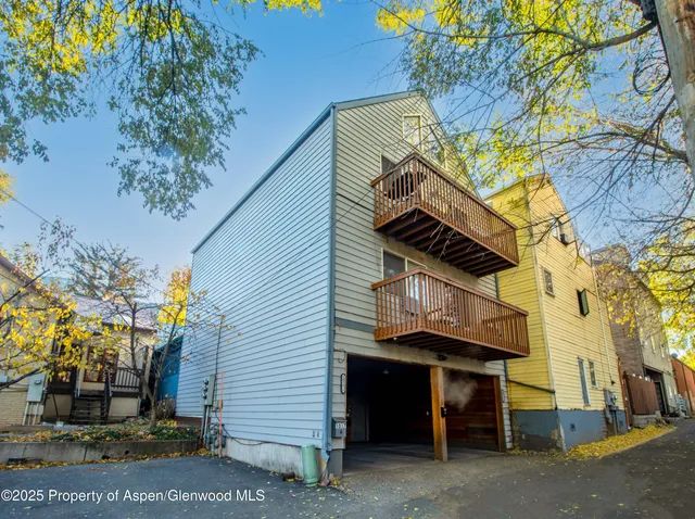 a view of a house with a tree and wooden fence