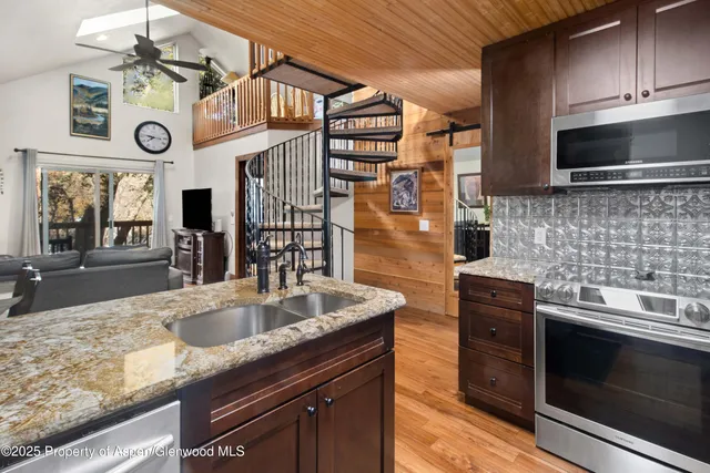 a kitchen with stainless steel appliances granite countertop a sink and a stove