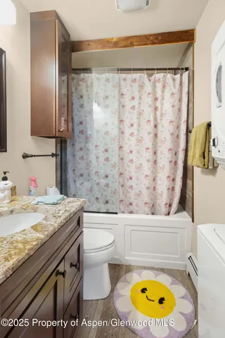 a bathroom with a granite countertop toilet sink and mirror