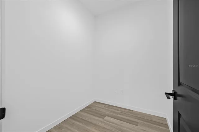 a view of a room with wooden floor and white walls