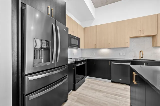 a kitchen with kitchen island granite countertop stainless steel appliances and sink