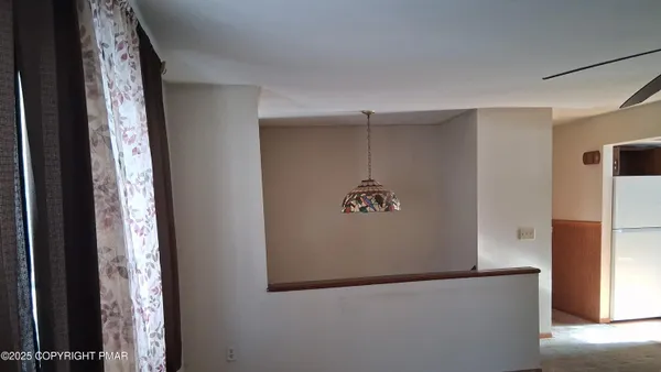 a view of a hallway with windows and chandelier