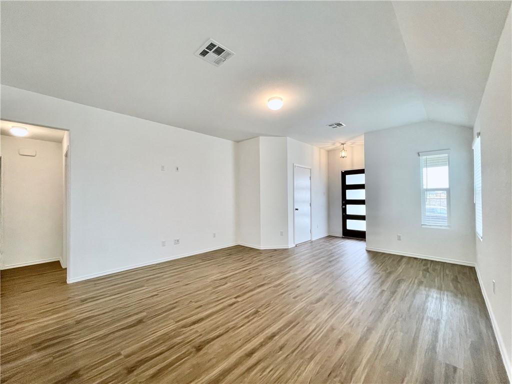 126 Canley Loop Hutto, TX 78634 - Photo 4 of 24 wooden floor in an empty room with a window