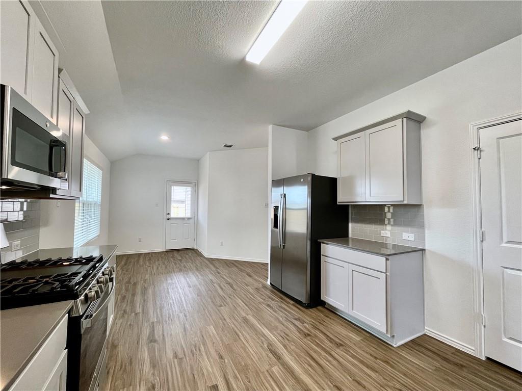 126 Canley Loop Hutto, TX 78634 - Photo 10 of 24 a kitchen with stainless steel appliances a refrigerator stove and microwave
