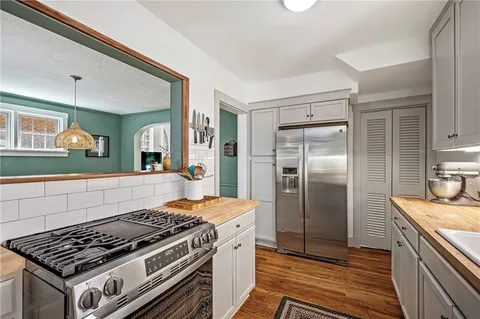 a kitchen with stainless steel appliances granite countertop a stove a refrigerator and a sink