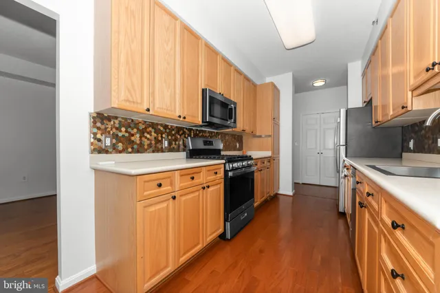 a view of a big room with wooden floor and kitchen