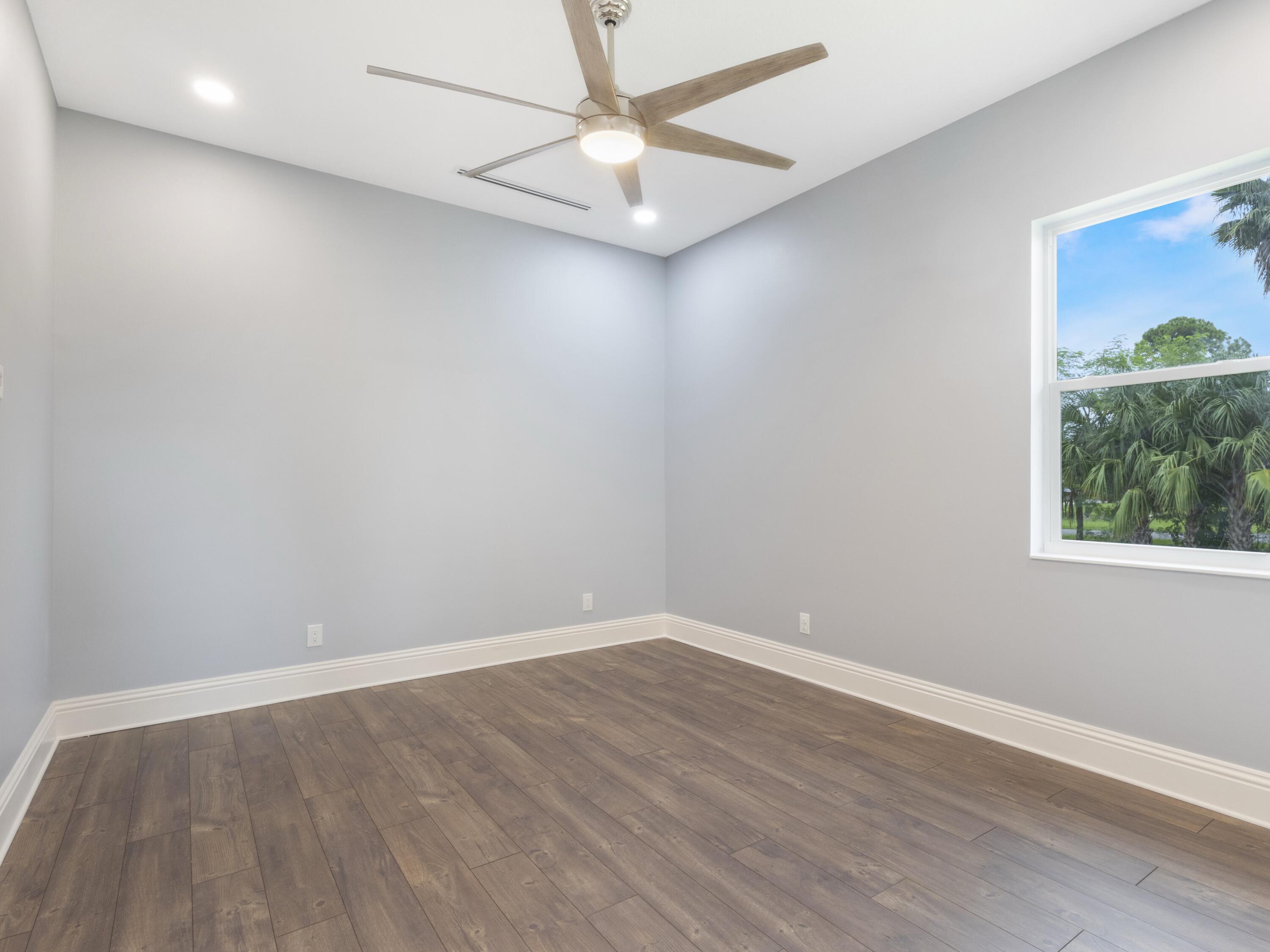 17436 71st Lane North Loxahatchee, FL 33470 - Photo 40 of 50 wooden floor in an empty room with a window