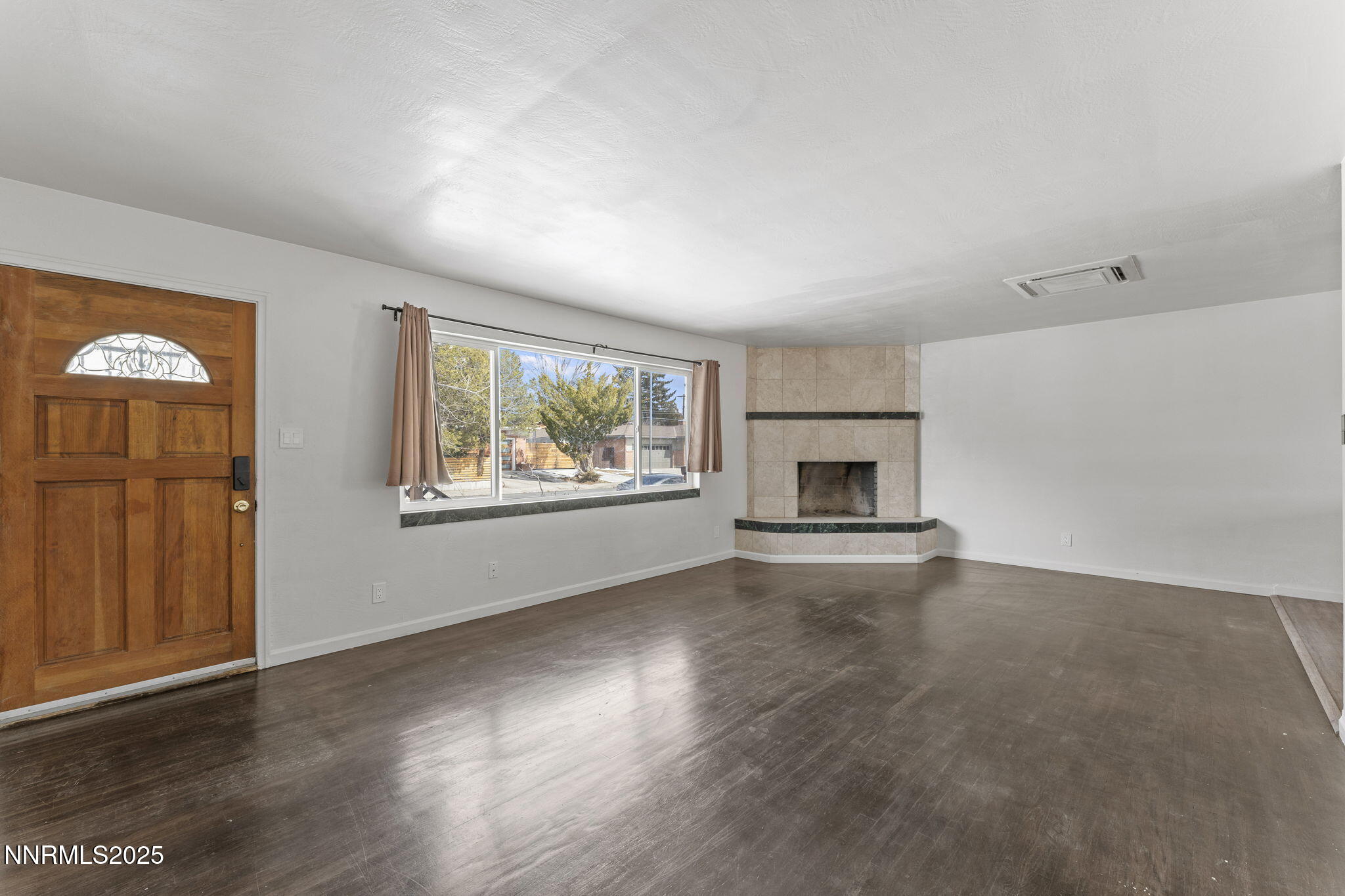 840 Brookfield Drive Reno, NV 89503 - Photo 8 of 42 an empty room with wooden floor fireplace and windows