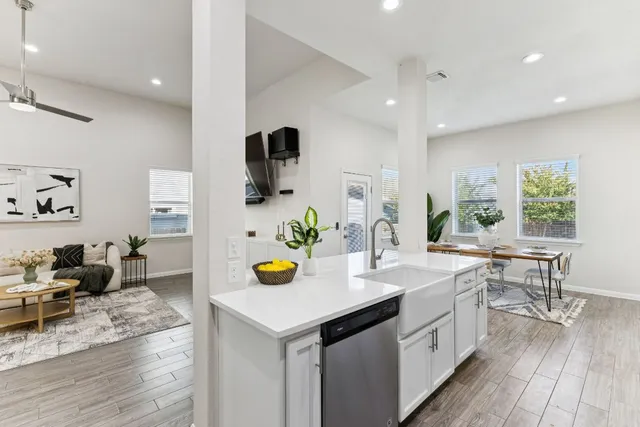 a kitchen with a sink a counter space and living room