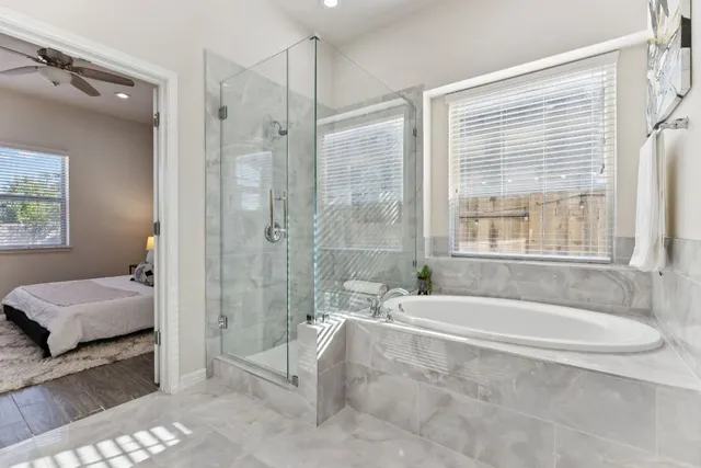 a spacious bathroom with a tub shower and window