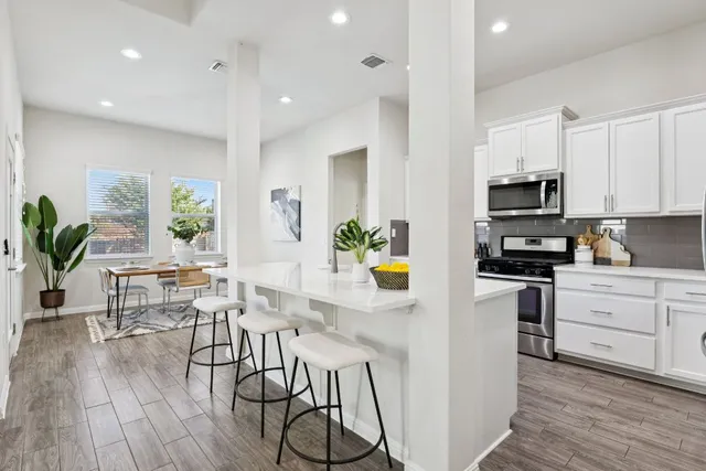 a kitchen with stainless steel appliances a stove a sink a microwave a refrigerator and cabinets