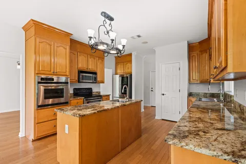a kitchen with stainless steel appliances a counter top space and wooden floor
