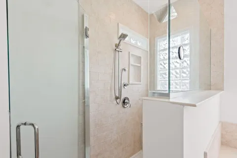 a bathroom with double vanity sink a mirror and a shower
