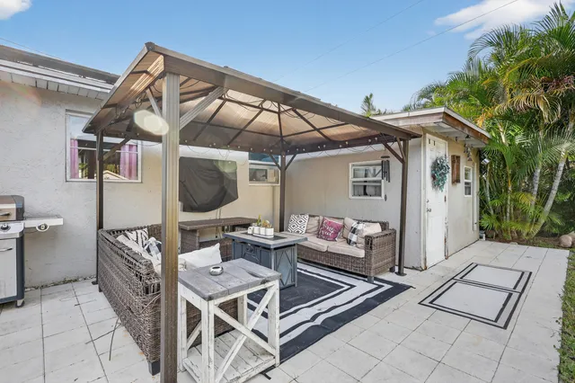 a view of a patio with lawn chairs under an umbrella