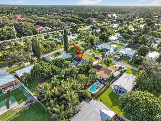 an aerial view of residential houses with outdoor space and trees