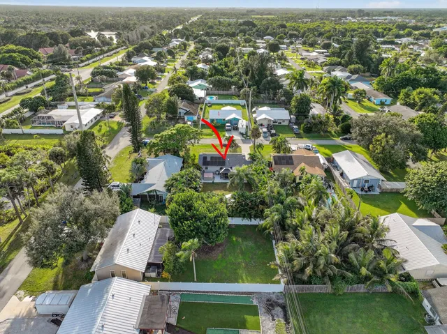 an aerial view of residential houses with outdoor space and trees