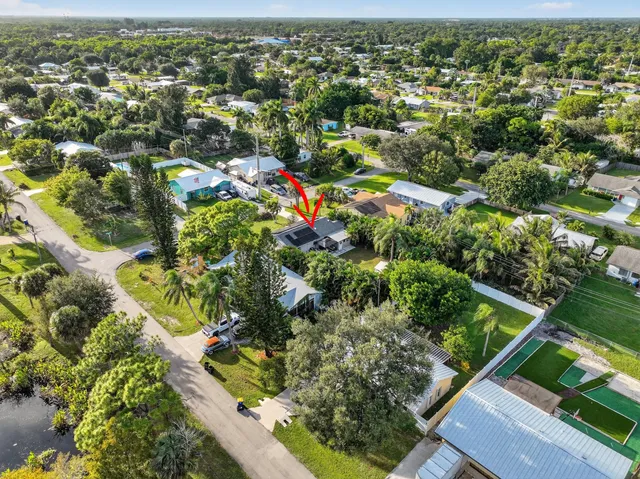 an aerial view of residential houses with outdoor space and swimming pool