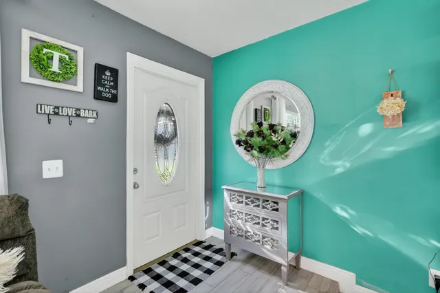 a living room with furniture kitchen view and a chandelier