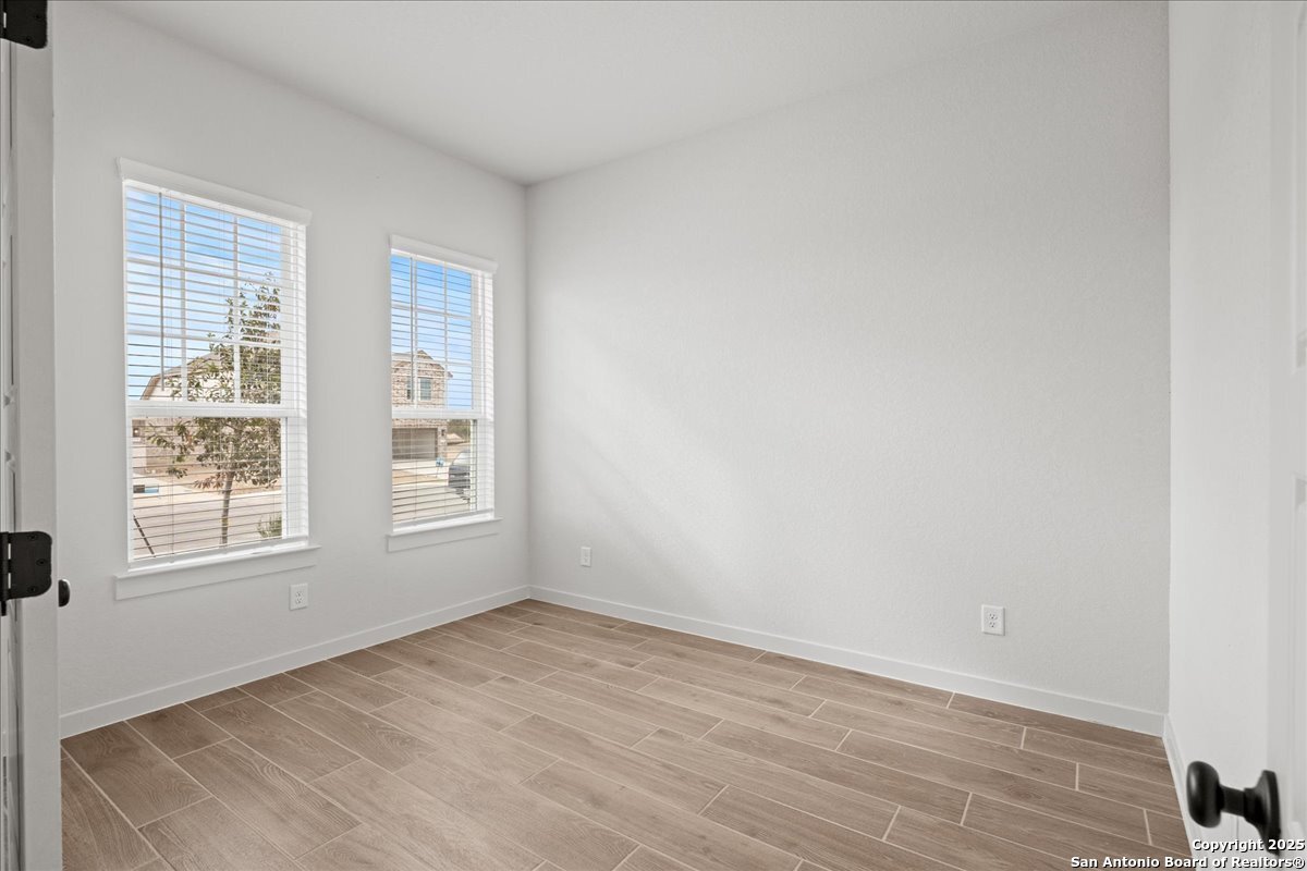 2134 Shepards Street Seguin, TX 78155 - Photo 11 of 24 an empty room with wooden floor and windows