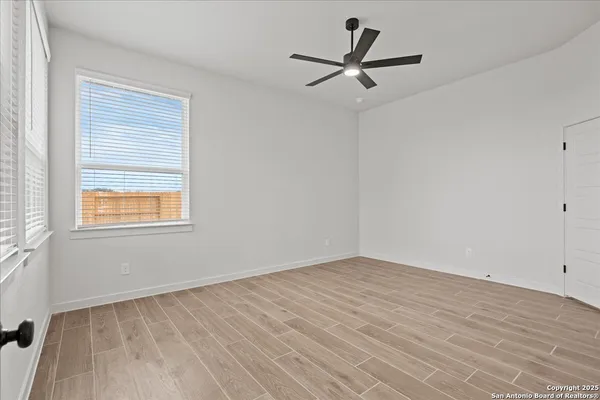 a view of a room with wooden floor and a ceiling fan