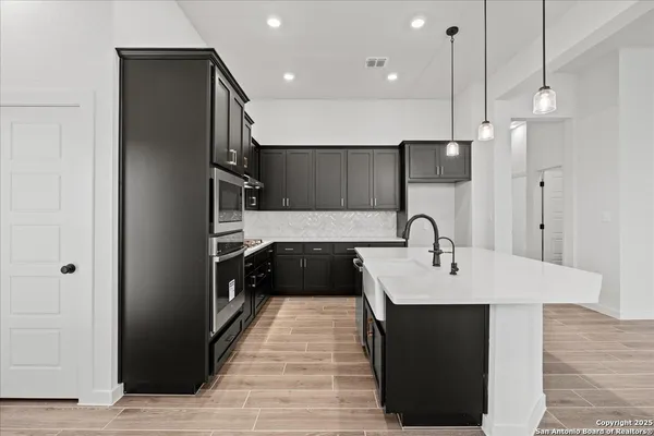 a kitchen with a sink refrigerator and microwave