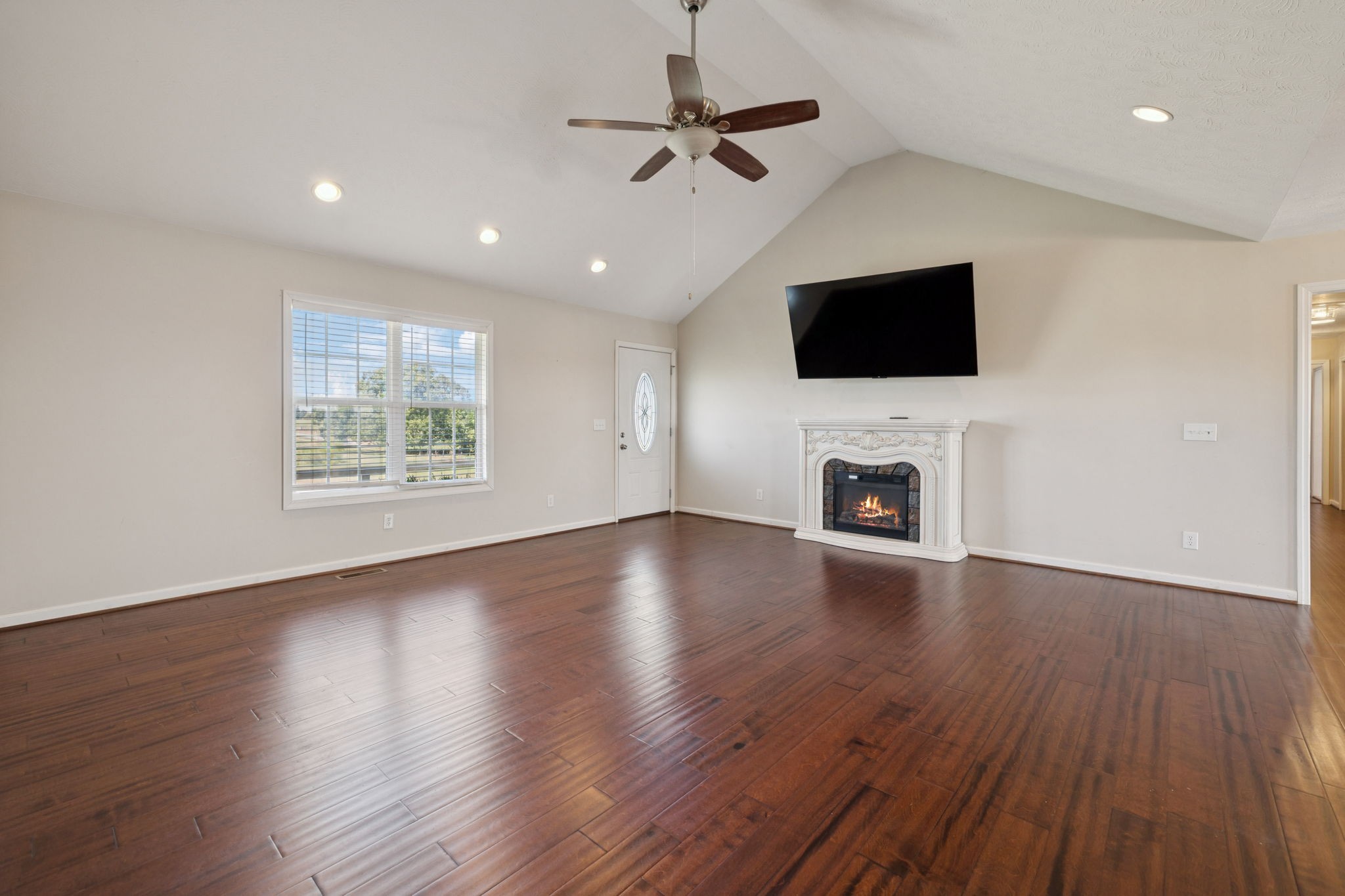 800 Williams Road Lafayette, TN 37083 - Photo 5 of 49 a view of a livingroom with a flat screen tv wooden floor and a ceiling fan