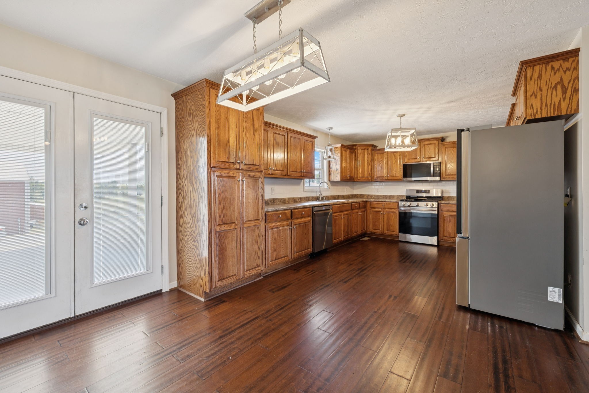 800 Williams Road Lafayette, TN 37083 - Photo 7 of 49 a kitchen with stainless steel appliances granite countertop a refrigerator a sink dishwasher a stove and a wooden floor